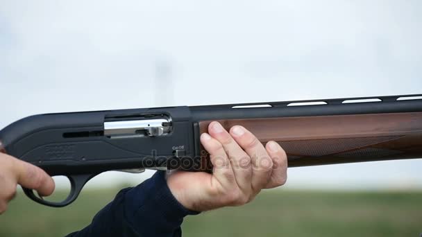 El hombre apunta, aprieta un gatillo, y dispara a un blanco de arcilla en un campo en slo-mo — Vídeo de stock