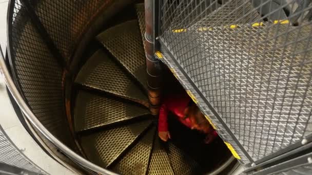 Νεαρή γυναίκα αναρρίχηση μια σπειροειδή σκάλα μετάλλων στην Πράγα το φθινόπωρο — Αρχείο Βίντεο