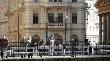 Prague, Çek Cumhuriyeti - 24 Mart, yürüyüş boyunca sahte bir çit ve beyaz banklar Vltava quay slo-mo üzerinde 2017:Tourists