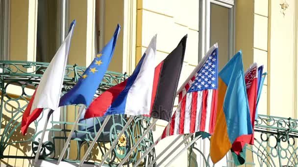 Государственные флаги некоторых стран, движущихся в замедленной съемке над каким-то зданием в Праге — стоковое видео
