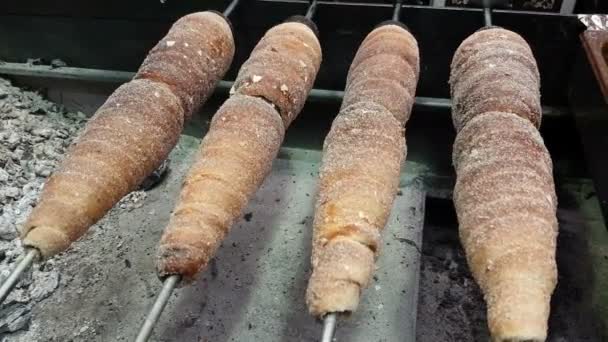 Rotisserie de pães em alguns cuspes de metal em um forno aberto em alguma rua na Europa — Vídeo de Stock