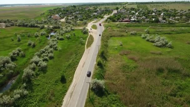 Fotografia aérea de uma estrada rural que leva a uma pequena aldeia na Europa Oriental — Vídeo de Stock
