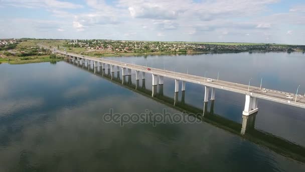 Аэросъемка автомобильного моста с беспилотником, летящим вдоль него в солнечный день — стоковое видео