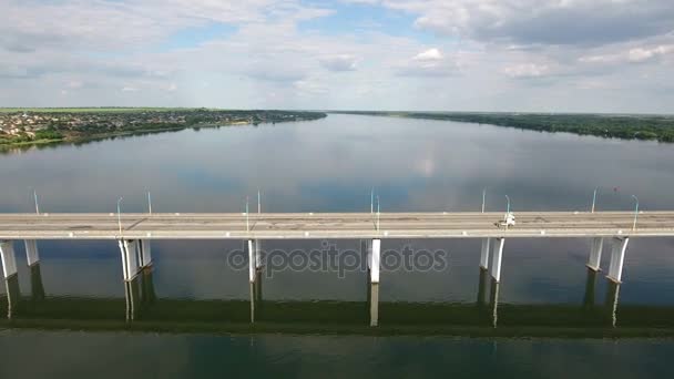 Luchtfoto van de brug van een auto met een drone vliegen weg in een zonnige dag — Stockvideo