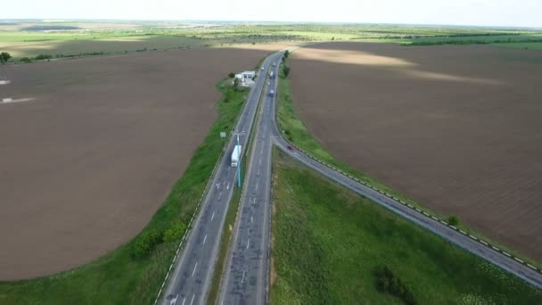 Aerial strzał prosto autostrada z samochodów i zielone pola uprawne, w pobliżu — Wideo stockowe