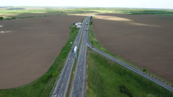 Arabalar ve yakın yeşil tarım alanları ile düz bir otoyol hava atış — Stok video