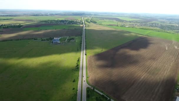 Zdjęcia lotnicze z autostrady kraju prosto z szerokie zielone pola leżące w pobliżu — Wideo stockowe