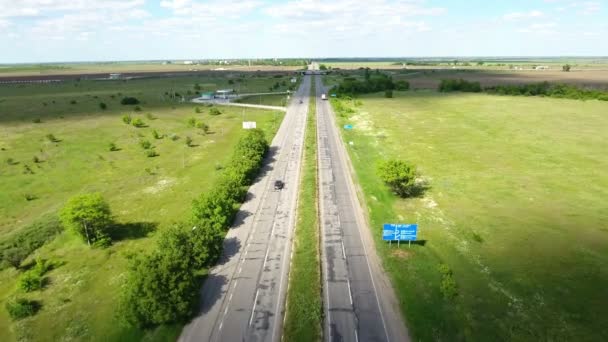 Skudd fra luften på en landevei med biler og grønne landbruksområder i nærheten – stockvideo