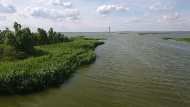 Antenn skott Dzharylhach ön inflöden och en fyr i bakgrunden — Stockvideo