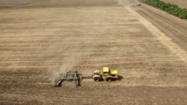Bir harrow çekerek sarı traktör ve tarım alanı hava atış