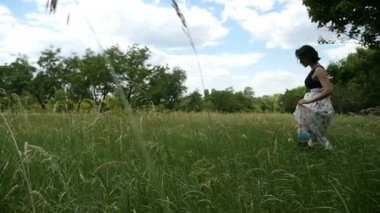 Ağır çekimde yüksek çim sahası, Doğu Avrupa'da ince kadın geçer