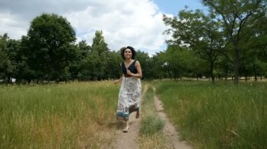 Genç kadın gülümsüyor ve ishal bir halk bir ülkede yol boyunca çekimde elbise