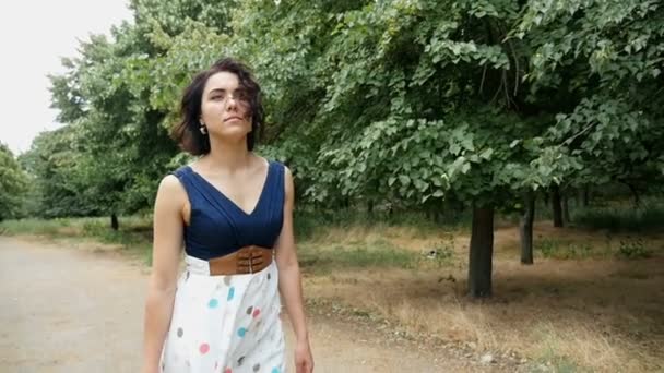 Jonge vrouw gaat langs een landweg in Oekraïne in de zomer in slow motion — Stockvideo