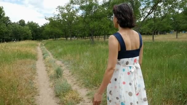 Jonge vrouw gaat langs een landweg in Oekraïne in de zomer in slow motion — Stockvideo