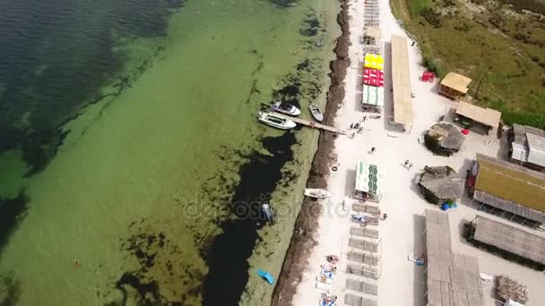 Luchtfoto van de bochtige Zeekust van Dzharylhach eiland met huizen en boten — Stockvideo