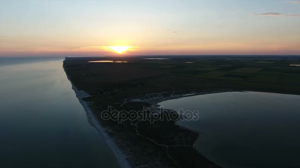 Luchtfoto van een enorme gele zon bij zonsondergang over een eiland in de Zwarte Zee — Stockvideo