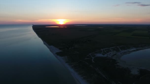 Luchtfoto van een grote oranje zon bij zonsondergang over een eiland in de Zwarte Zee — Stockvideo