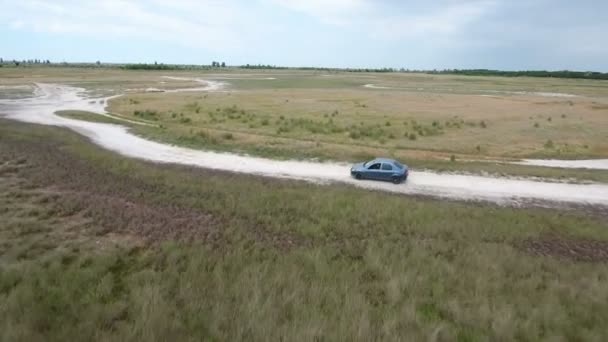 Foto aérea de un coche moviéndose de perfil a lo largo de algún camino rural en el Mar Negro — Vídeos de Stock