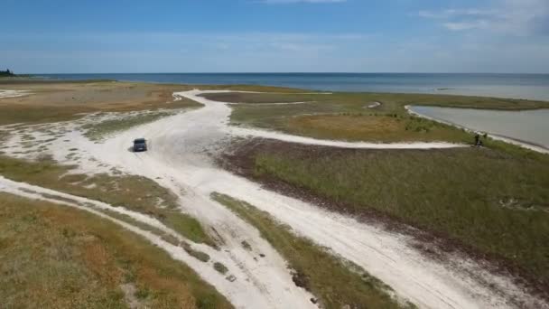 Luchtfoto van een zwarte jeep rijden langs de landweg aan de Zwarte Zee — Stockvideo