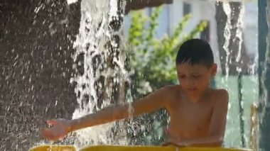 küçük çocuk akarsu şelale altında su parkı mutludur