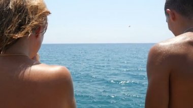 Genç adam ve kadın koşmak ve ayak ilk yavaş denize atlamak.