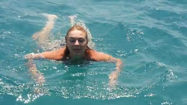 Νεαρή γυναίκα πηγαίνει στη θάλασσα-μπάνιο στα γαλαζοπράσινα νερά του Αιγαίου σε slo-mo — Αρχείο Βίντεο