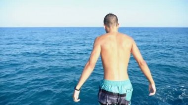 Şortlu genç adam kafa önce slo-mo Bizanslılar deniz sularında atlar