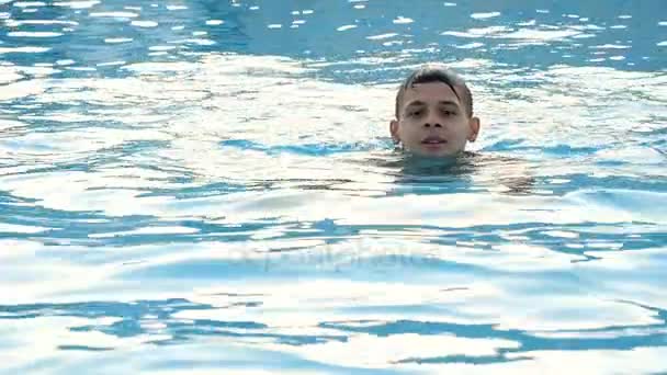 Young man swims breaststroke in blue sea waters on a sunny day in slow motion — Stock Video