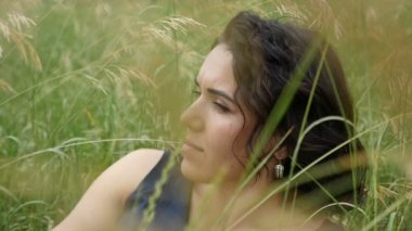 Romantik kız güzel bir çim üzerinde yatıyor ve bir kenara thoughfully yavaş çekimde görünüyor