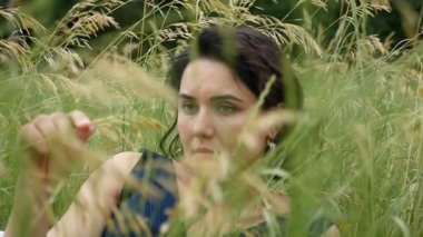 Çekici bir esmer kız slo-mo güneşli bir günde bir alanda yatıyor