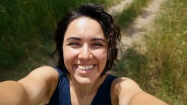 Genç esmer kız mutlu bir şekilde gülümsüyor ve slo-mo yaz aylarında sol ve sağ turnike