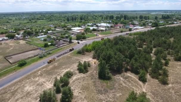 Fotografia aérea de uma estrada chantagem e reparação em um dia ensolarado no verão — Vídeo de Stock