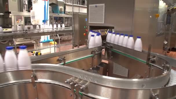 Sebuah garis connveyor melengkung dengan botol susu bergerak di pabrik hi-tech di Ukraina — Stok Video