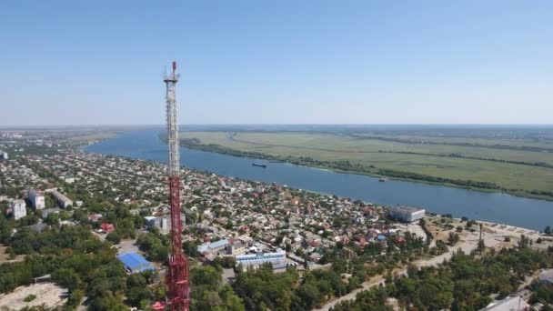 Повітряний постріл металевого телевежа на березі Дніпра з високих будівель навколо — стокове відео