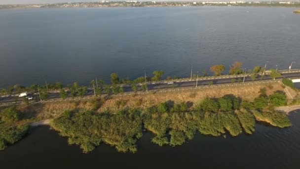 Luchtfoto van een snelweg die zich uitstrekt over een smalle streep land in zee wateren — Stockvideo