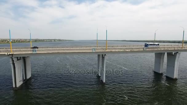 Een bird's eye shot van een lange brug met lantaarnpalen over de Dnipro in de zomer. — Stockvideo