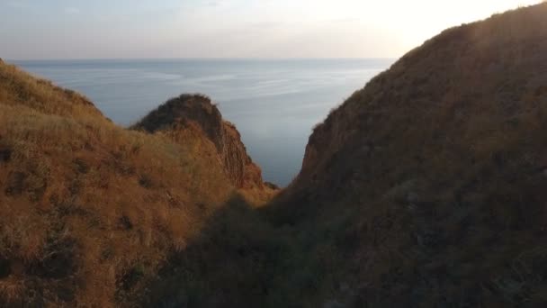 Aeriall tiro de colinas de arcilla en una espléndida puesta de sol en una série en verano — Vídeos de Stock