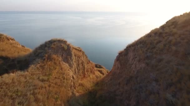 Foto aérea de colinas de arcilla con sagebrush. Espléndido mar. Una lancha flotando lejos — Vídeos de Stock
