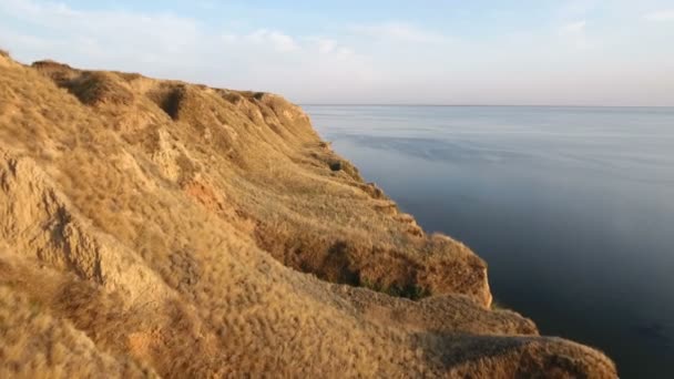 Vue aérienne de collines brunes sur la côte de la mer Noire avec des eaux bleues scintillantes — Video