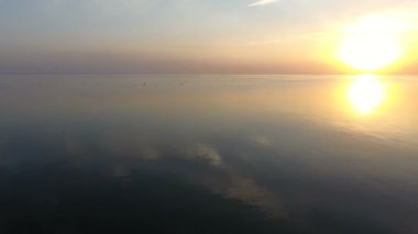 Parıldayan deniz suları üzerinde parlayan bir günbatımı güneşli bir yaz aylarında hava atış