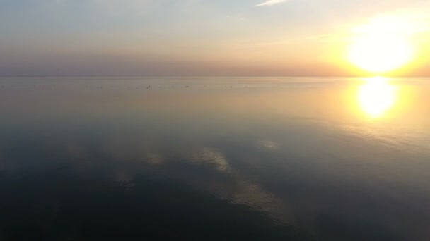 Vue aérienne d'un coucher de soleil radieux sur des eaux de mer chatoyantes par une journée ensoleillée en été — Video