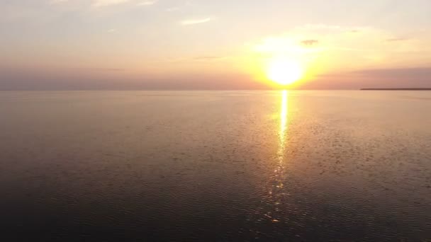 Tiro aéreo de um pôr-do-sol esplêndido sobre águas do mar cintilantes em um dia ensolarado no verão — Vídeo de Stock