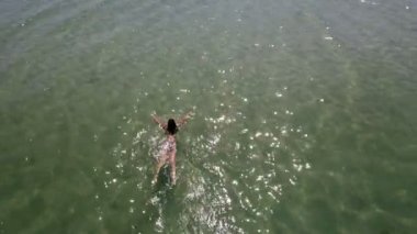 Hava bir ince kız mavi deniz dalgalar halinde yaz aylarında yüzme fotoğrafını