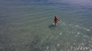 Mavi deniz dalgaları içine yaz aylarında çalışan genç bir kadın hava atış