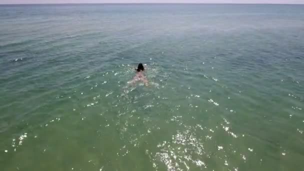 Foto aérea de una chica delgada nadando como una sirena en las olas del mar en verano — Vídeos de Stock