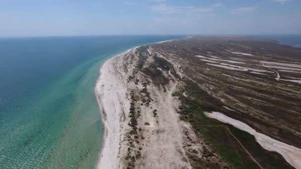 Luchtfoto van een wild uitziende kuststreek van Dzarylhach eiland met patches van onkruid — Stockvideo