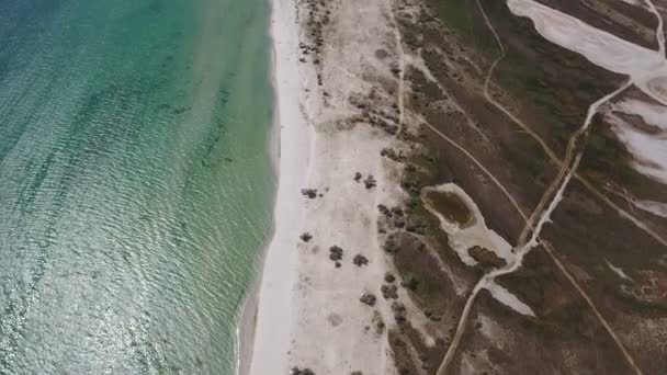 Luchtfoto van een zandstrand kuststreek van Dzarylhach eiland met patches van onkruid — Stockvideo