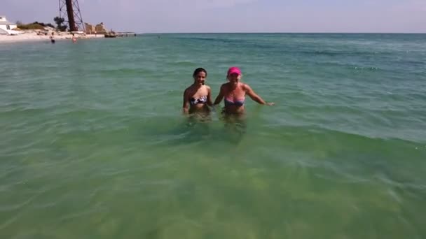 Ein Mädchen und eine Frau unterhalten sich im Wasser des Schwarzen Meeres unweit eines Grenzturms — Stockvideo