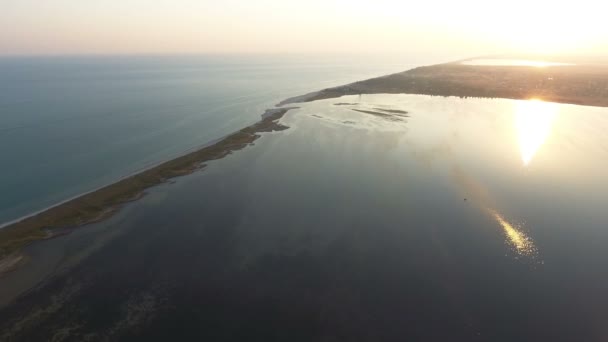 Colpo aereo dello stretto spiedo terrestre coperto di giunco e erbacce al tramonto — Video Stock