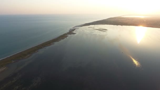 Lanzamiento aéreo de la estrecha saliva terrestre cubierta de junco y malezas al atardecer — Vídeo de stock